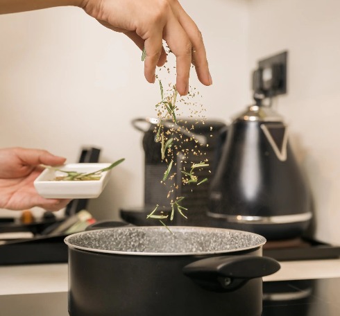 Person cooking in Dao by Dorsett AMTD Singapore room kitchenette