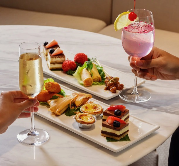 Two people enjoying drinks and food platters in a restaurant in Singapore.