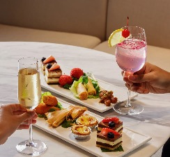 Two people enjoying drinks and food platters in a restaurant in Singapore.