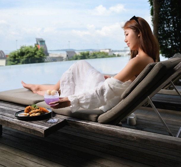 Lady on a sunlounger enjoying a meal at Dao by Dorsett AMTD Singapore