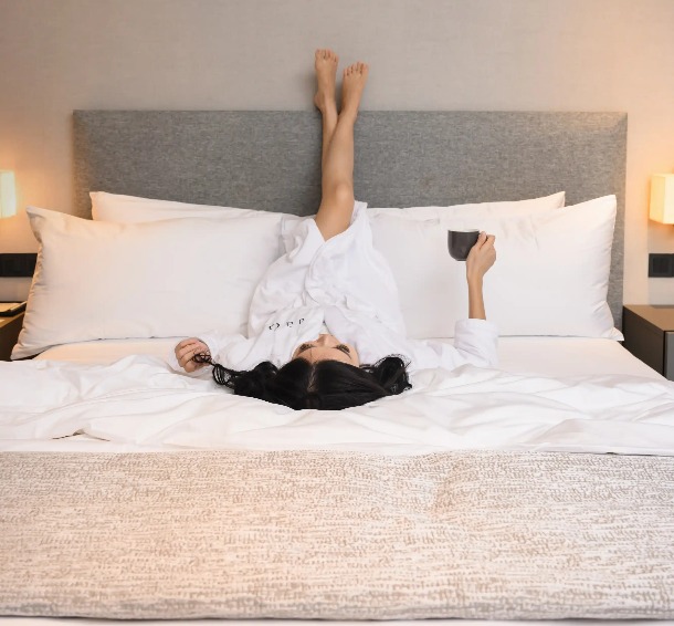 A lady on a king-size bed in a bedroom Dao by Dorsett AMTD Singapore.