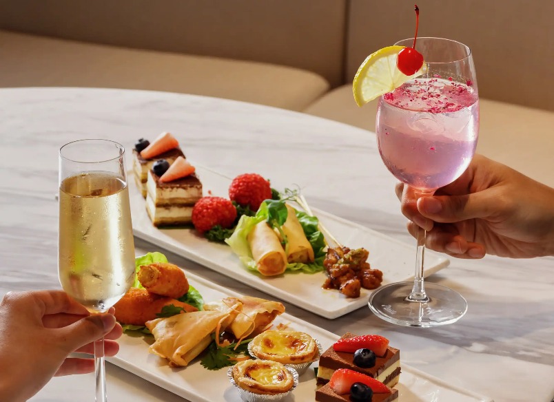 Two people enjoying drinks and food platters in a restaurant in Singapore.