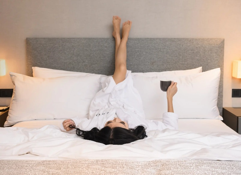 A lady on a king-size bed in a bedroom Dao by Dorsett AMTD Singapore.