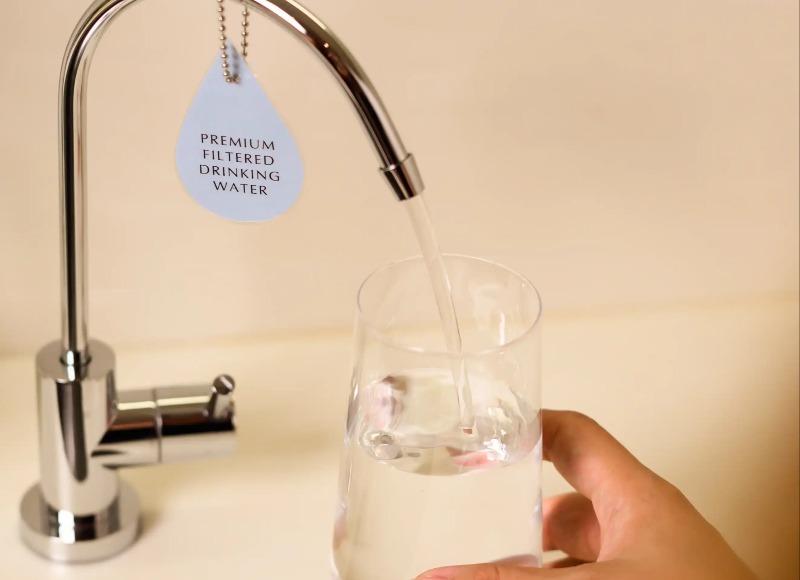 A Person filling a glass of water at Dao by Dorsett AMTD Singapore.