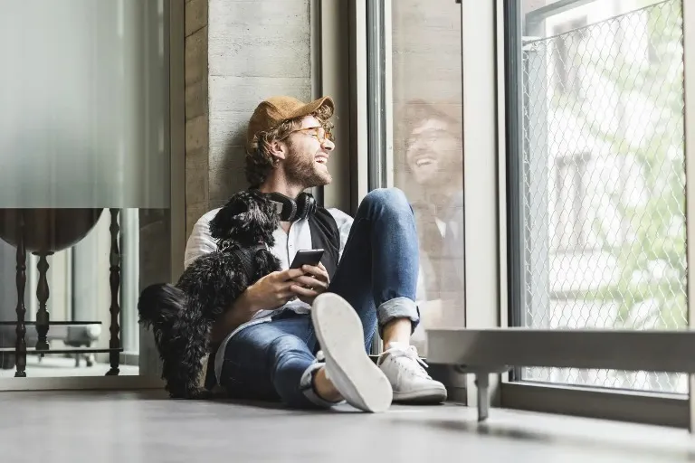 A man with a puppy is looking out the window in Dao by Dorsett Hotel.