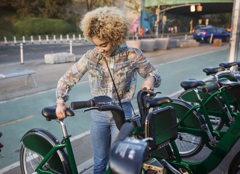 A lady parking her bicycle in the pavement