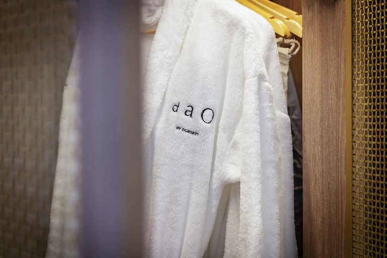 Dao by Dorsett Bathrobes hung on racks in a cupboard. 