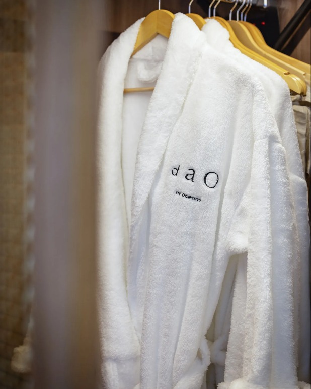 Dao by Dorsett Bathrobes hung on racks in a cupboard. 