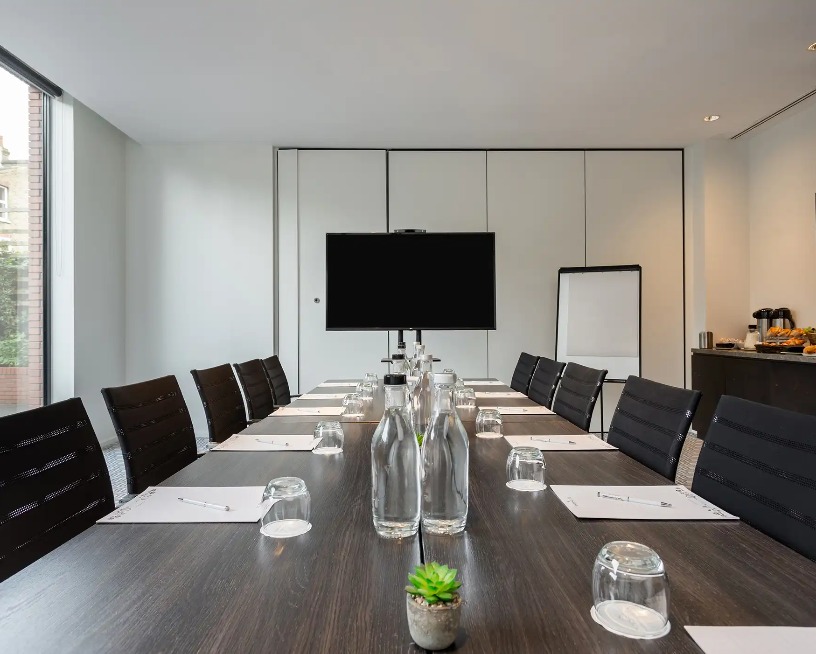 Conference table for 12 and a TV  in the Heron Suite, West London.