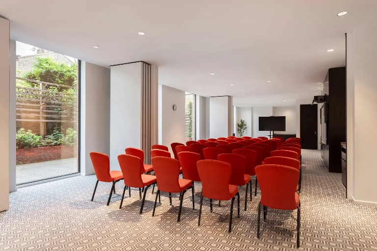 45 chairs and a TV set on a TV stand in the front of the meeting room at Dao by Dorsett West London Hotel