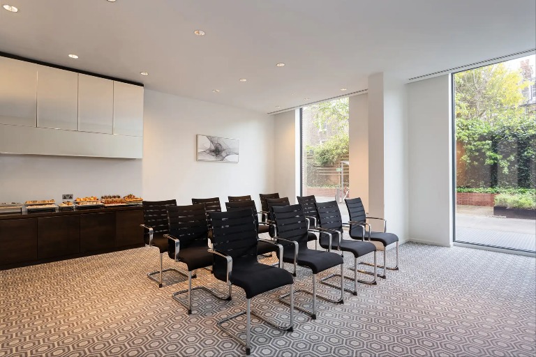 Twelve tables in the Dorsett Lounge, a white-themed meeting room at Dao by Dorsett West London Hotel