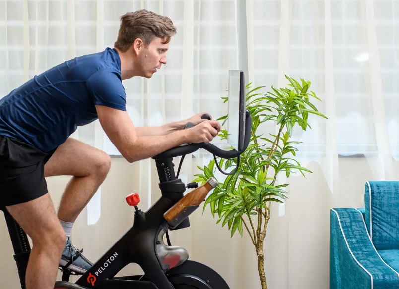 Man cycling an exercise bike in a Dao by Dorsett West London Hotel Room.