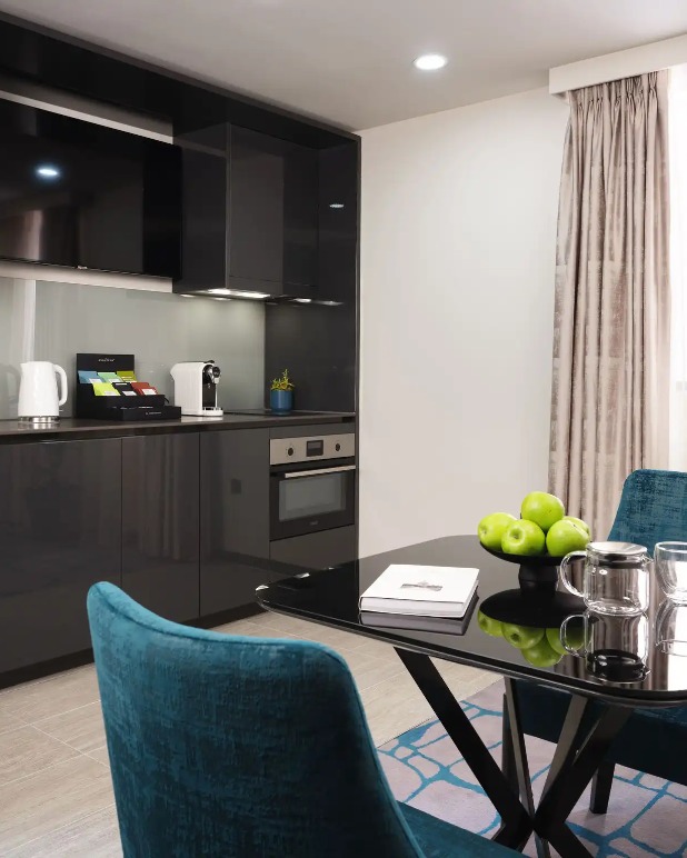 Kitchenette and table in a Dao by Dorsett North London Hotel room.