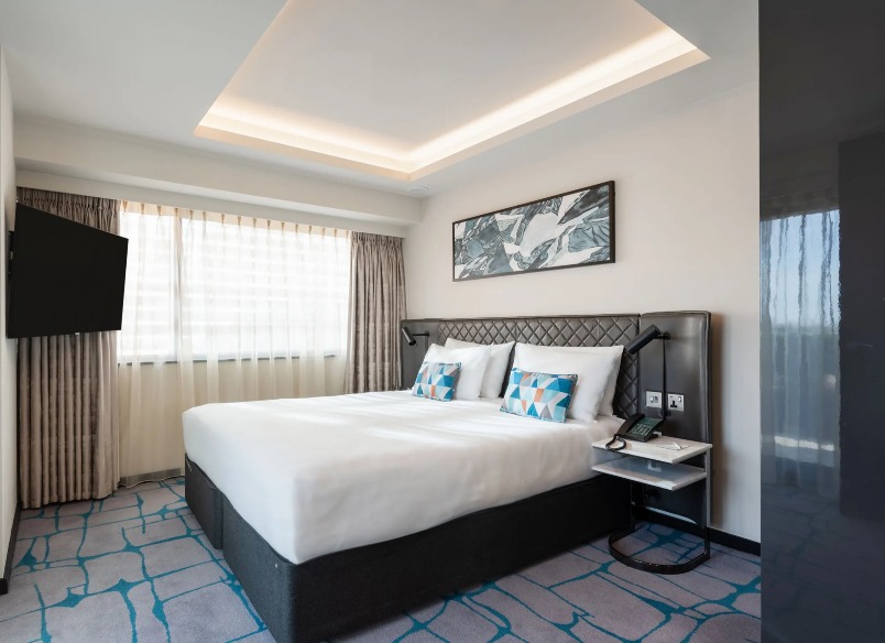 King-size bed with a TV and a bedside table in the Premium One-Bedroom Terrace at Dao by Dorsett West London Hotel.