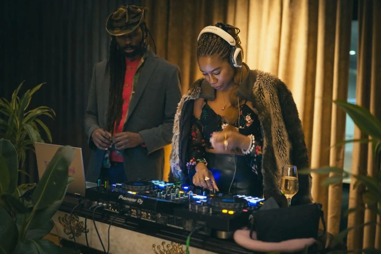 A woman doing DJ and a man next to her.